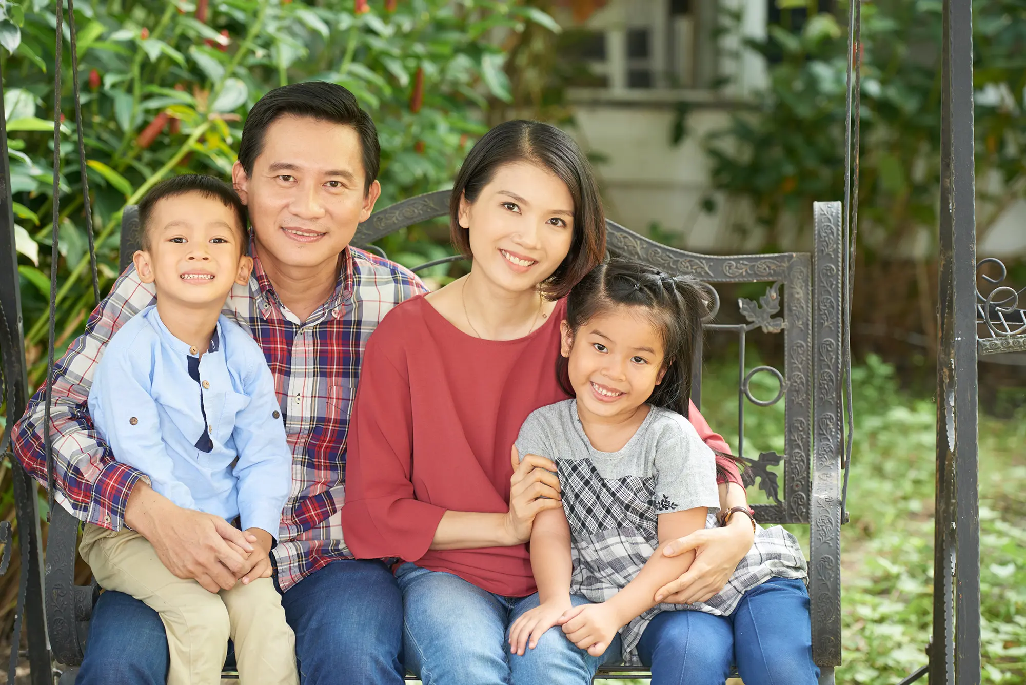 A Filipino family sitting together on a bench outdoors