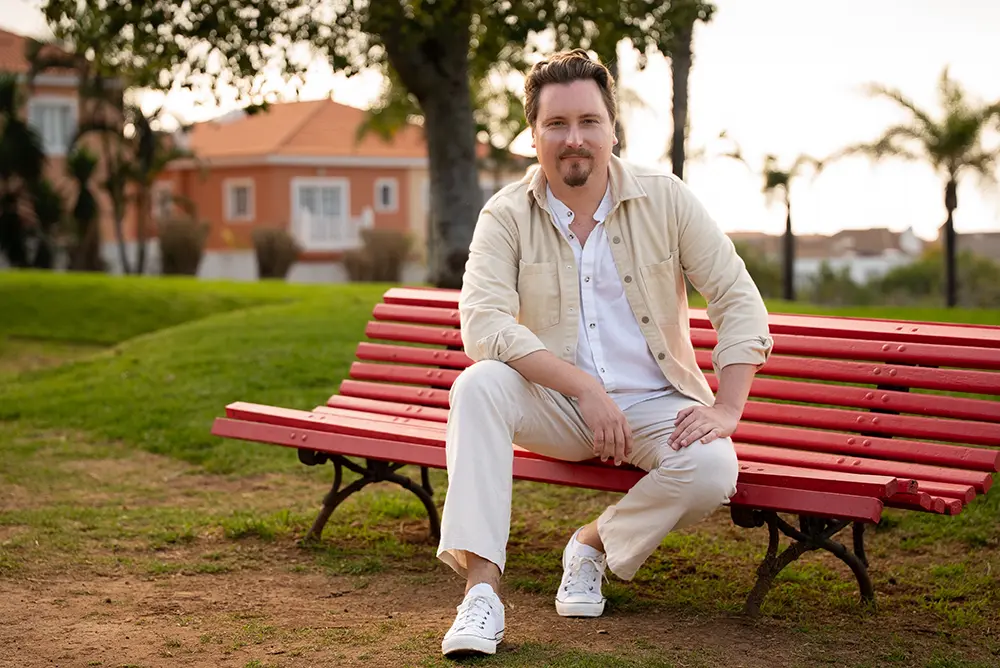 Photo of the author sitting on a red bench